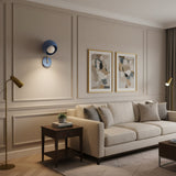 Blue Oslo dome wall sconce featuring a rounded shade, white globe bulb and brass accent arm.