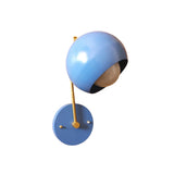 Side angle view of Oslo blue dome wall sconce with globe bulb, brass arm and round wall canopy.