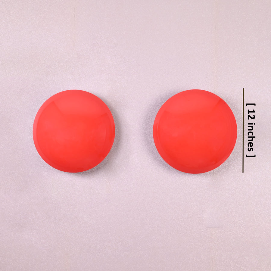 Set of two red disc wall sconces glowing with warm ambient halo, modern eclipse-inspired brass wall lighting