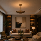 Palermo 5 light brass tone perforated bowl chandelier installed in a modern living room with warm ambient lighting.