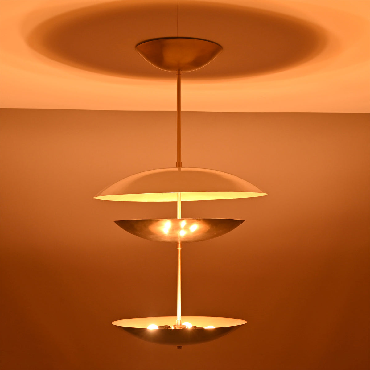 Palermo Tiered Saucer Chandelier illuminated side view showing three tiered saucer shades and soft ambient light.