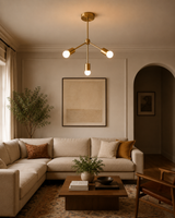 Paros 3 light brass chandelier displayed above a warm contemporary living room with cream seating and wood furniture.