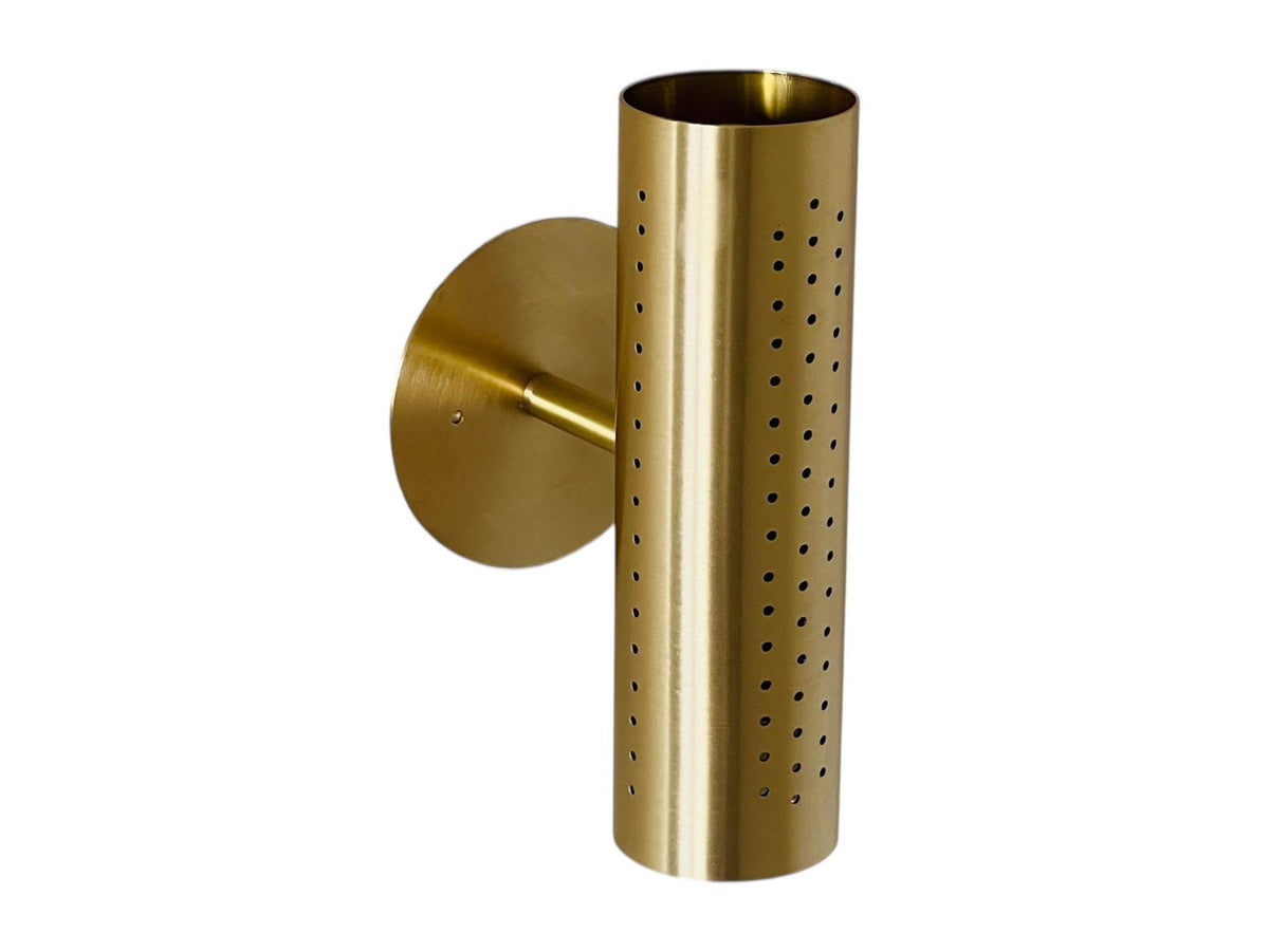 Angled view of brushed brass perforated cylinder wall sconce with round backplate on a white background.