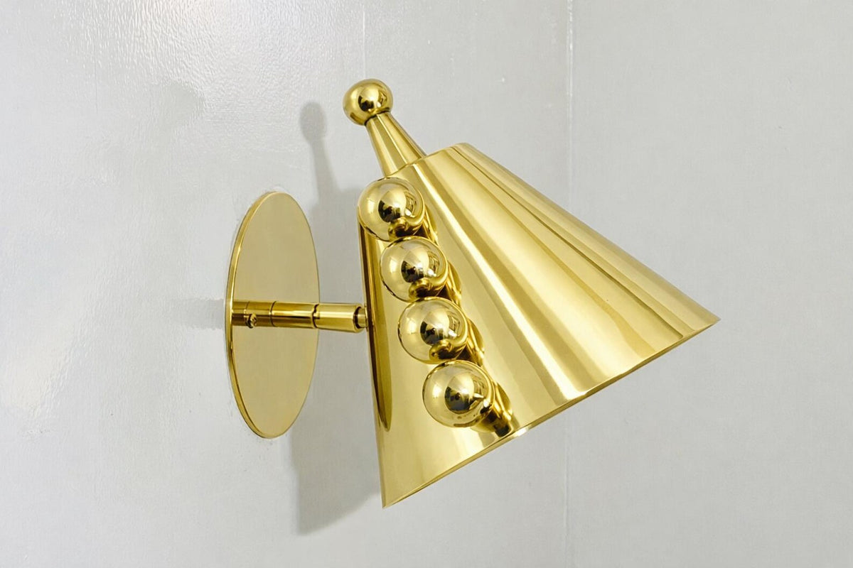 Angled profile of polished brass cone wall sconce highlighting the cone shade shape and brass ball detailing.