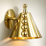 Side view of polished brass cone wall sconce showing round backplate, arm, and vertical row of brass ball accents.