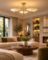 Positano 3-light ivory bowl chandelier illuminating a warm modern living room with a cream sectional sofa, round walnut coffee table, fireplace, and elegant neutral decor.