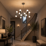 Prague 12 light silver-tone sculptural chandelier illuminated in a contemporary staircase entryway with warm ambient lighting.