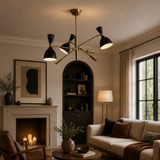 Queenstown 6 light black cone chandelier displayed in a warm contemporary living room with brass-tone arms and ambient lighting.