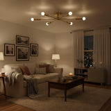 Ravenna 6 light brass-tone Sputnik flush mount chandelier shown illuminated with warm glowing exposed bulbs.