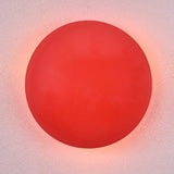 Modern red circular wall sconce with soft glowing ambient halo, handmade brass design