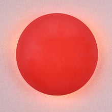 Modern red circular wall sconce with soft glowing ambient halo, handmade brass design