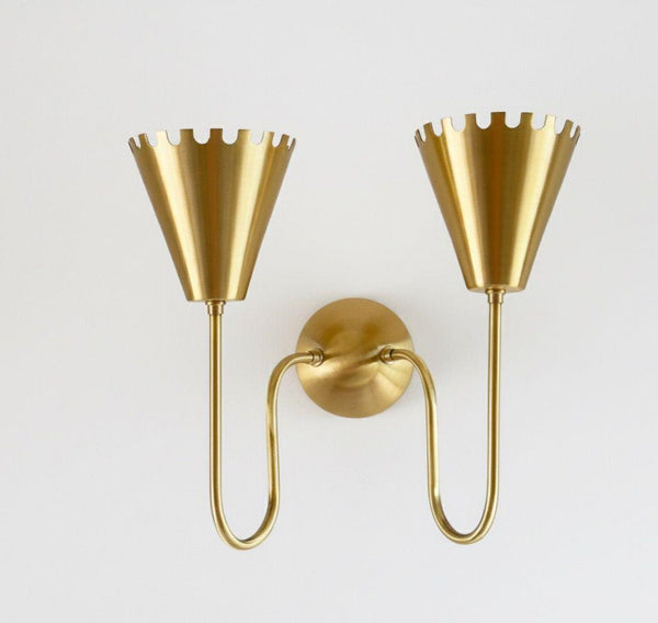 Front view of modern dual cone brass wall sconce with crown edge shades and curved arms in brushed brass finish