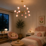 Rhodes 12 light pink globe Sputnik chandelier illuminated in a cozy bedroom with a polished brass frame.