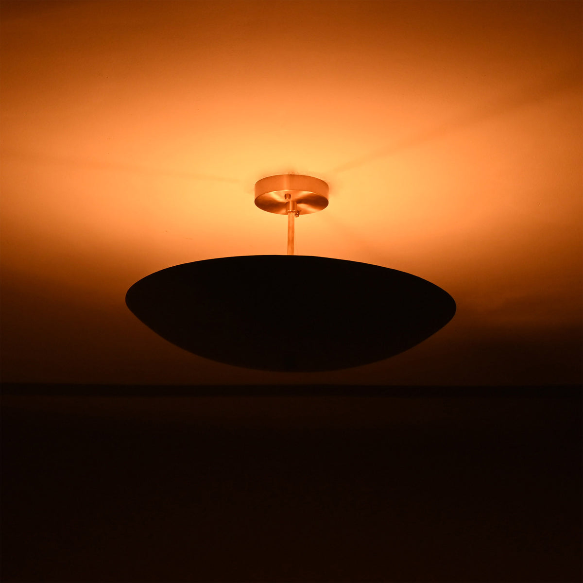 Side view of Rome Disc semi-flush ceiling light creating soft warm ambiance with a low-profile disc design.