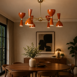 Saint Tropez 12 light orange Sputnik chandelier installed above a wooden dining table in a warm Mid-Century Modern dining room.