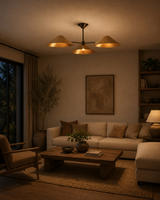 Santorini 3 light brass-tone cone chandelier illuminating a warm contemporary living room with neutral furniture.