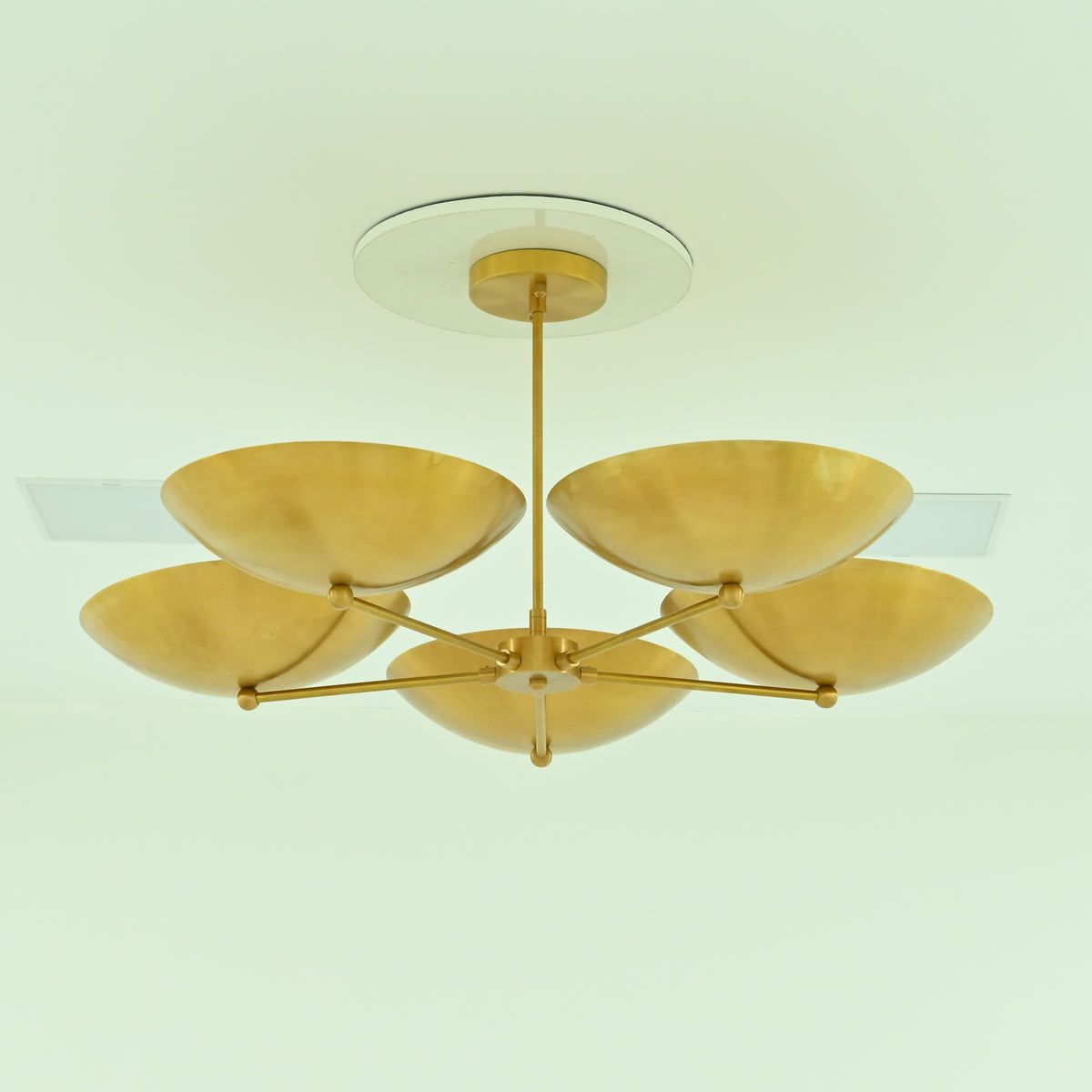Savannah 5-light gold bowl chandelier featuring five upward-facing metal saucer shades, sculptural brass arms, and a central downrod, shown with lights off.