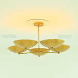 Illuminated Savannah 5-light brass chandelier featuring five sculptural gold bowl shades with softly glowing bulbs and warm ambient lighting.