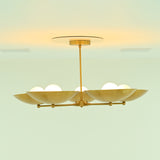 Side view of illuminated Savannah 5-light gold chandelier with upward-facing metal bowl shades and warm light reflecting across the brass finish.