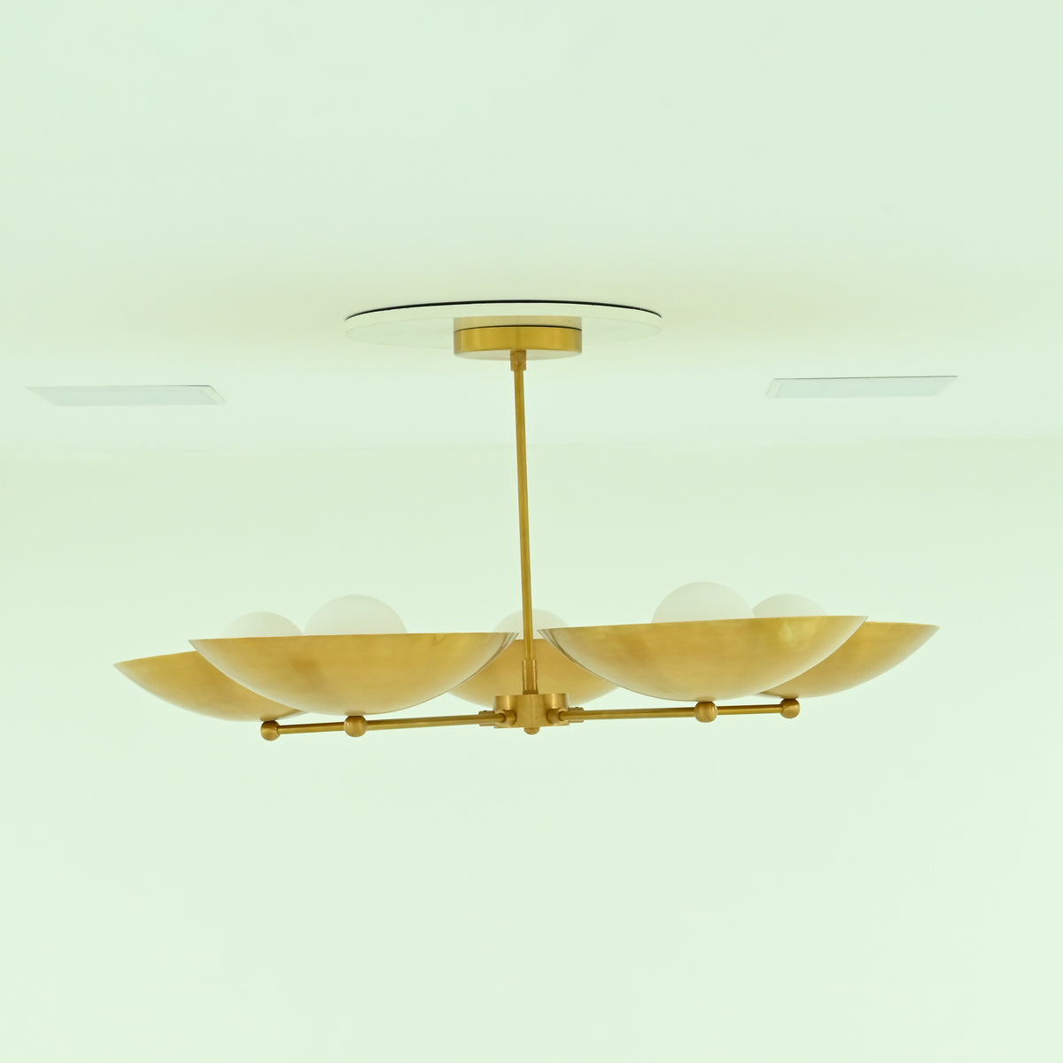 Side profile of Savannah 5-light mid-century modern chandelier with shallow gold bowl shades, radial brass arms, and a sleek ceiling-mounted downrod.