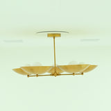 Side profile of Savannah 5-light mid-century modern chandelier with shallow gold bowl shades, radial brass arms, and a sleek ceiling-mounted downrod.