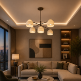 Savannah 5 light cream shade chandelier illuminated in a warm contemporary living room with sculptural bronze-tone arms.