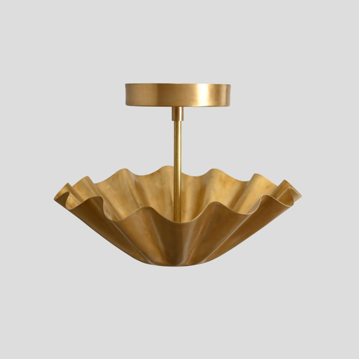 Sculpted brass wave semi-flush ceiling fixture with fluted edges and lacquered finish