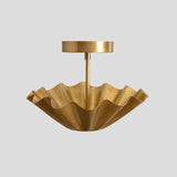 Sculpted brass wave semi-flush ceiling fixture with fluted edges and lacquered finish