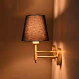 Side profile of the handcrafted antique brass wall sconce with a rich blue tapered fabric shade, showing its 9-inch projection and slim brass arm.