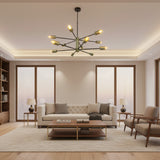 Siena 12 light Mid-Century Modern Sputnik chandelier with black radial arms and brass-tone cylindrical bulb holders shown illuminated from an angled view.