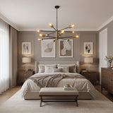 Siena 12 light Mid-Century Sputnik chandelier with brass-tone cylindrical holders and black arms shown illuminated from an angled perspective.