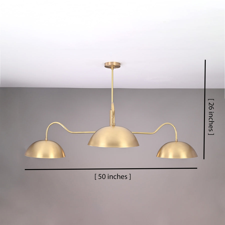 Siena Curved Arm chandelier glowing above a dining table in a cozy kitchen with warm ambient lighting.