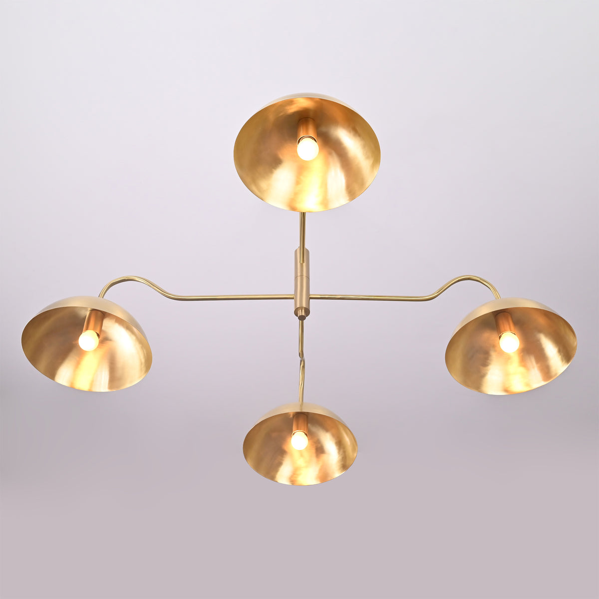 Bottom view of Siena Curved Arm chandelier with four glowing dome shades and warm reflected light.