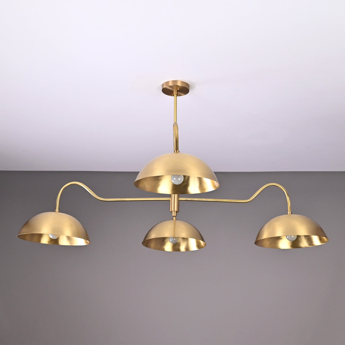 Siena Curved Arm chandelier featuring three dome shades, sculptural curved arms, and refined Mid-Century Modern styling.
