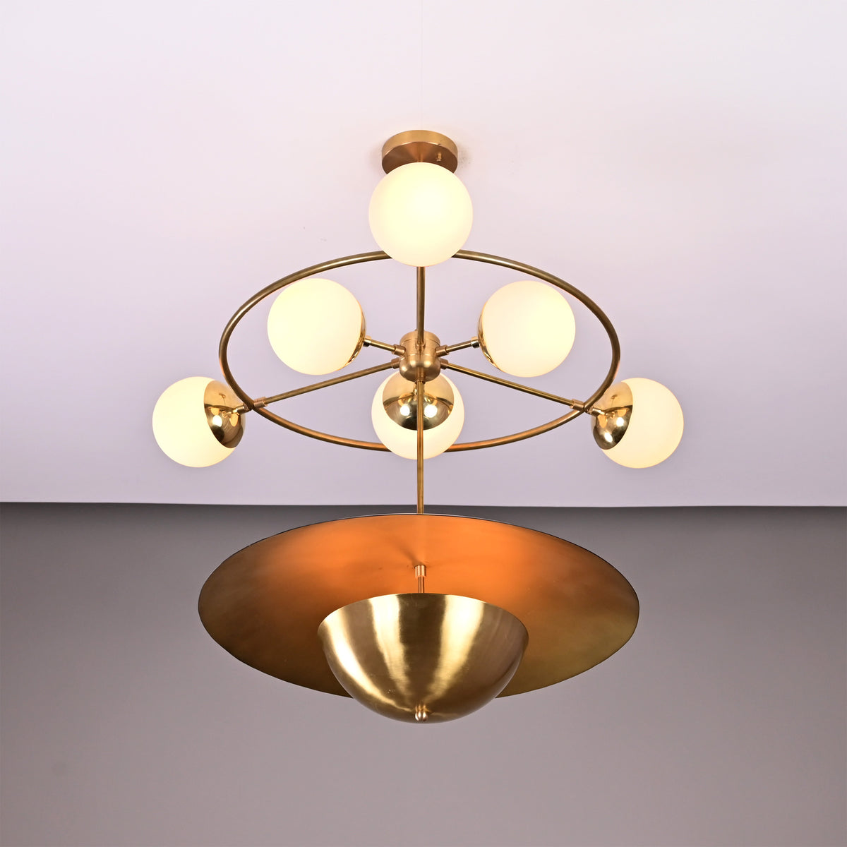Siena Globe Disc Chandelier shown with glowing globe lights and sculptural layered disc shade on neutral background.
