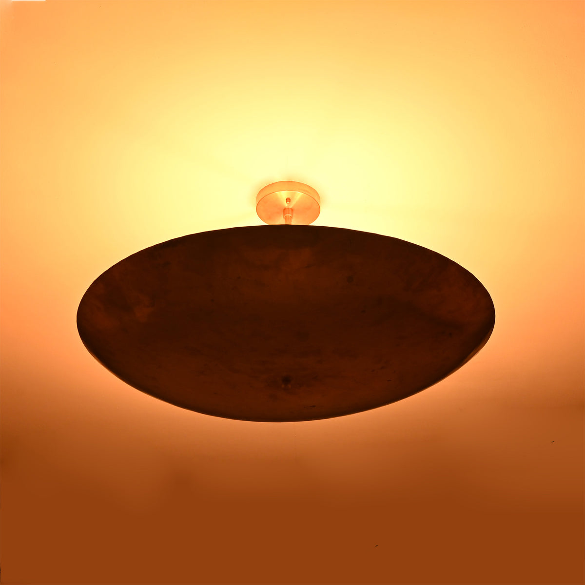 Siena Single Disc Chandelier illuminated against ceiling, creating a warm ambient glow around the fixture.