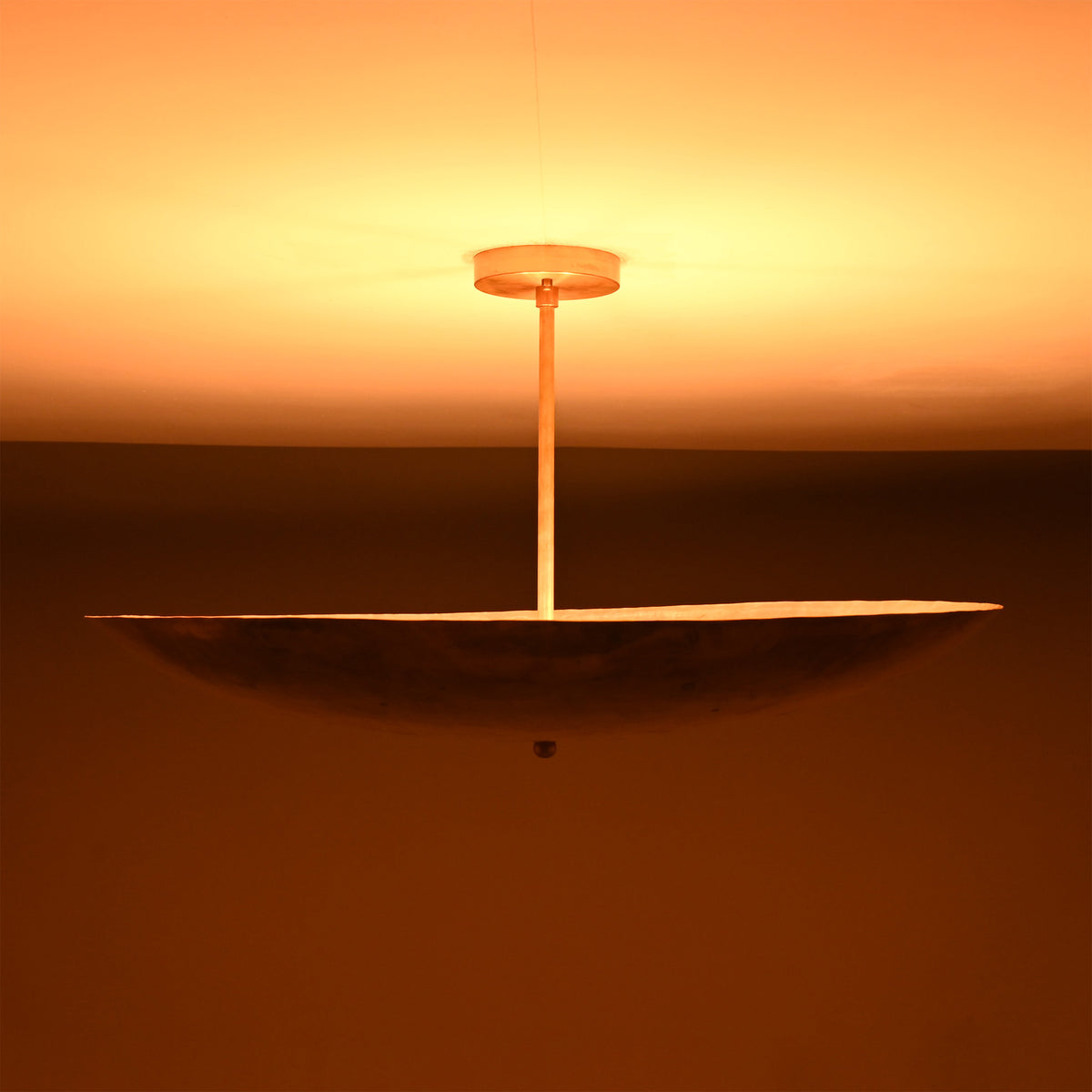 Siena Single Disc Chandelier lit from above, highlighting its wide disc form and soft indirect lighting.