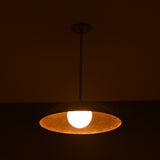 Wide view of lit brass pendant light casting ambient golden light, handmade by Brass Leaf Studio