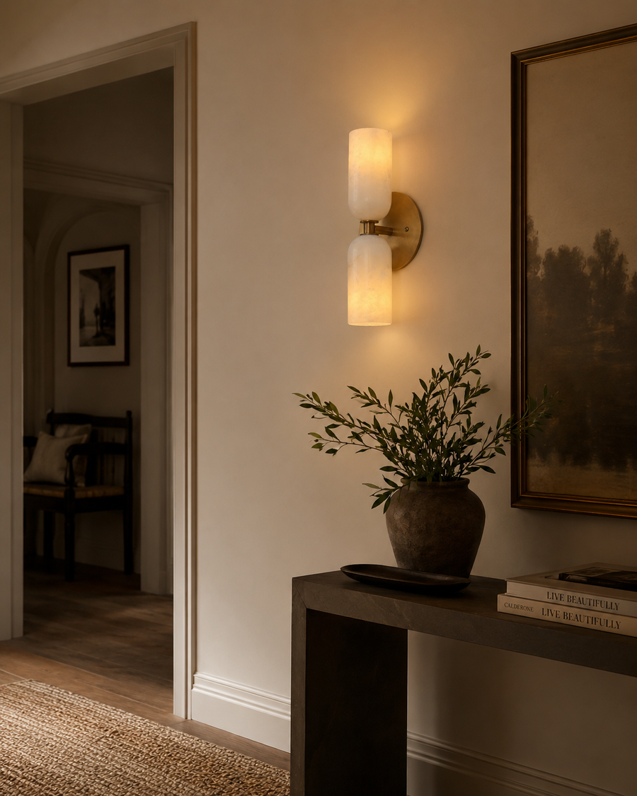 Sloane Double Cylinder Alabaster Wall Sconce installed in a modern hallway, providing warm ambient lighting with handcrafted alabaster shades and a solid brass finish.