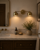 Sloane 2 light double dome brass wall sconce installed above a bathroom vanity with warm ambient lighting – Model 32811