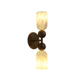 Side profile of the Sloane Dual Alabaster Globe Wall Sconce showcasing the slim vertical brass frame, spherical accents, and glowing alabaster cylinder shades.