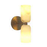 Sloane Dual Alabaster Wall Sconce with vertically stacked cylindrical alabaster shades illuminated on a brushed brass backplate, front view.