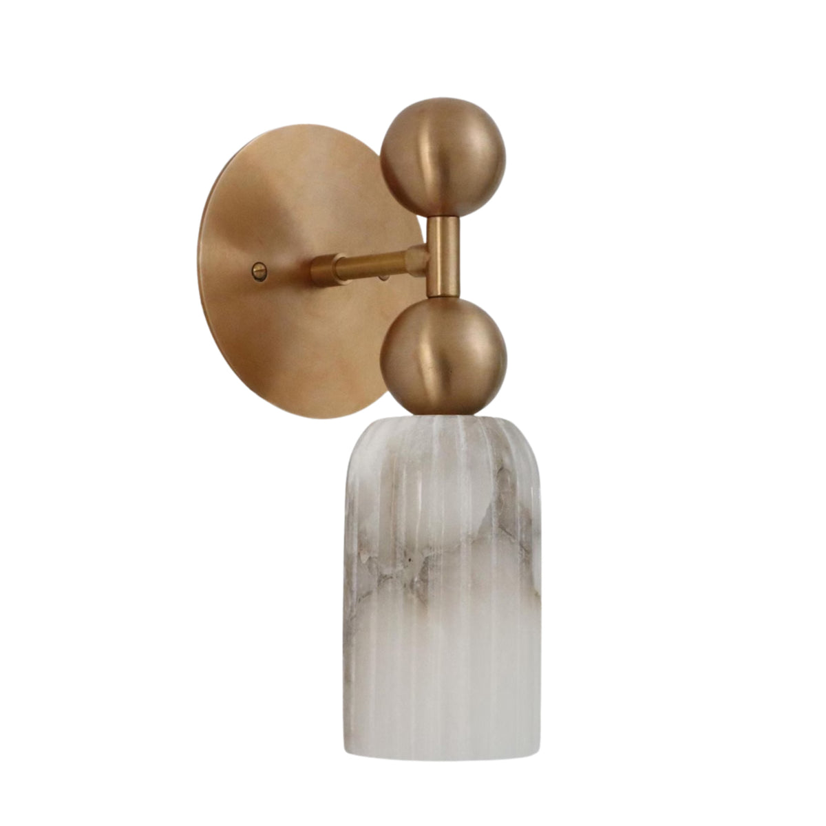 Three-quarter view of the Sloane Fluted Alabaster Wall Sconce highlighting the vertically fluted natural alabaster shade with sculptural brass globe detailing.