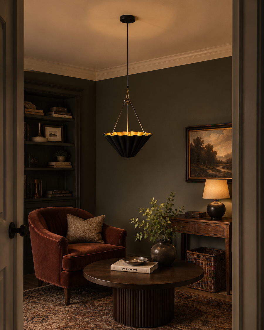 Sloane fluted bowl pendant light installed in a modern living room, providing warm ambient illumination with its brushed brass interior and sculpted black metal shade.