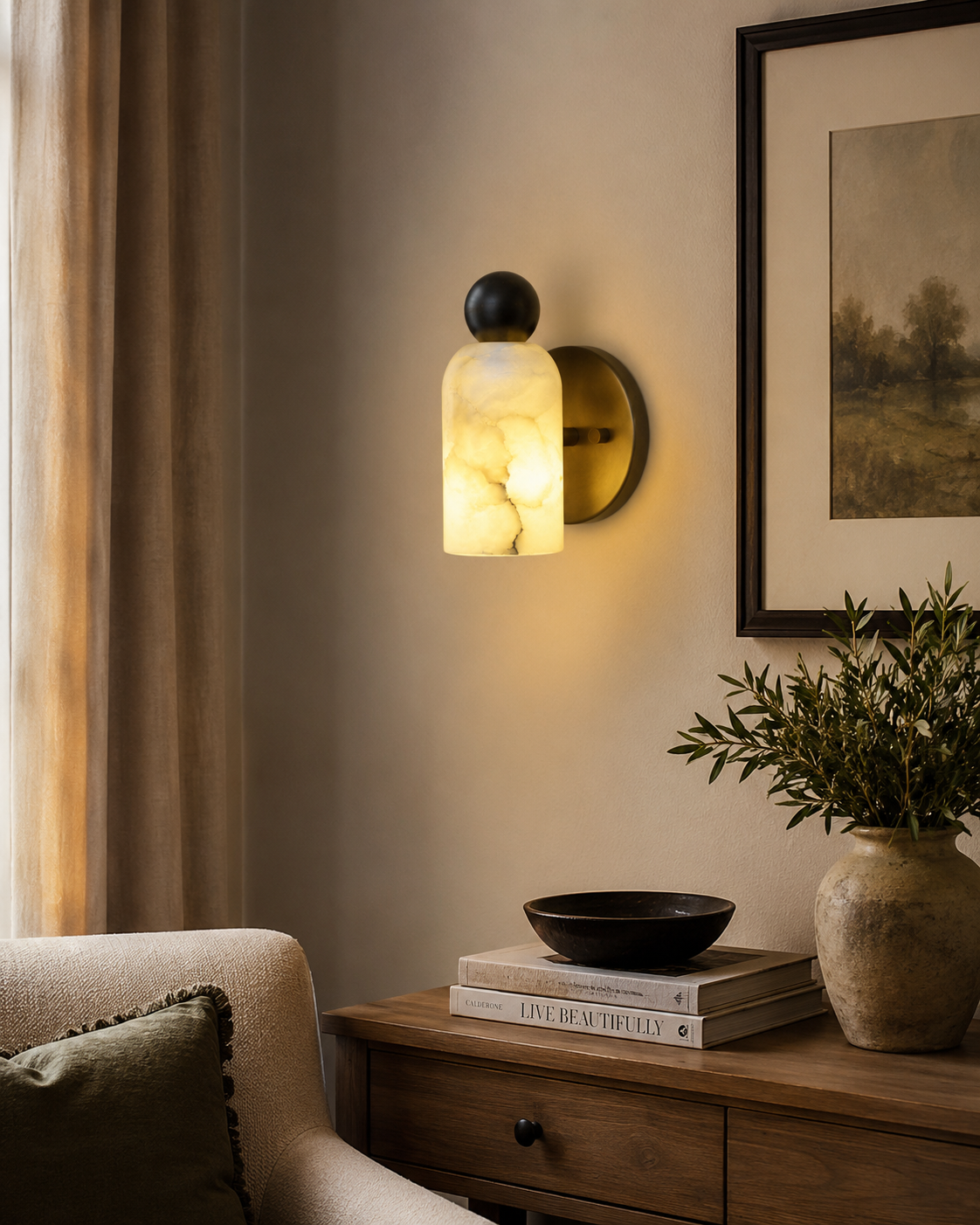 Sloane Rounded Alabaster Wall Sconce installed in a contemporary living room, providing warm ambient lighting beside a wooden console and neutral décor.
