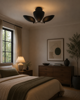 Sloane dark bronze sculptural petal flush mount installed on ceiling in a warm modern bedroom interior