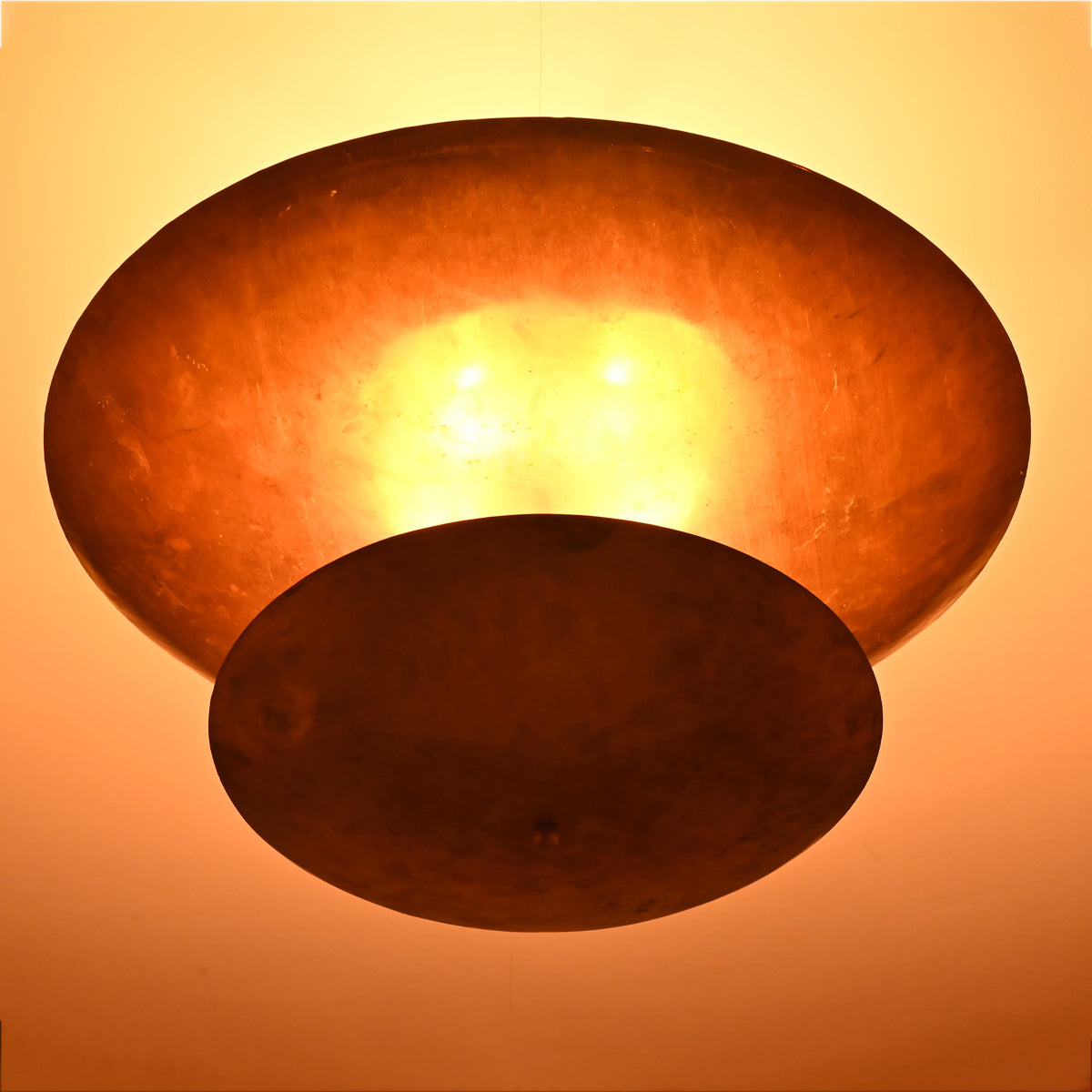 Close up of Solara Double Saucer Pendant Light highlighting warm diffused light between layered shades.