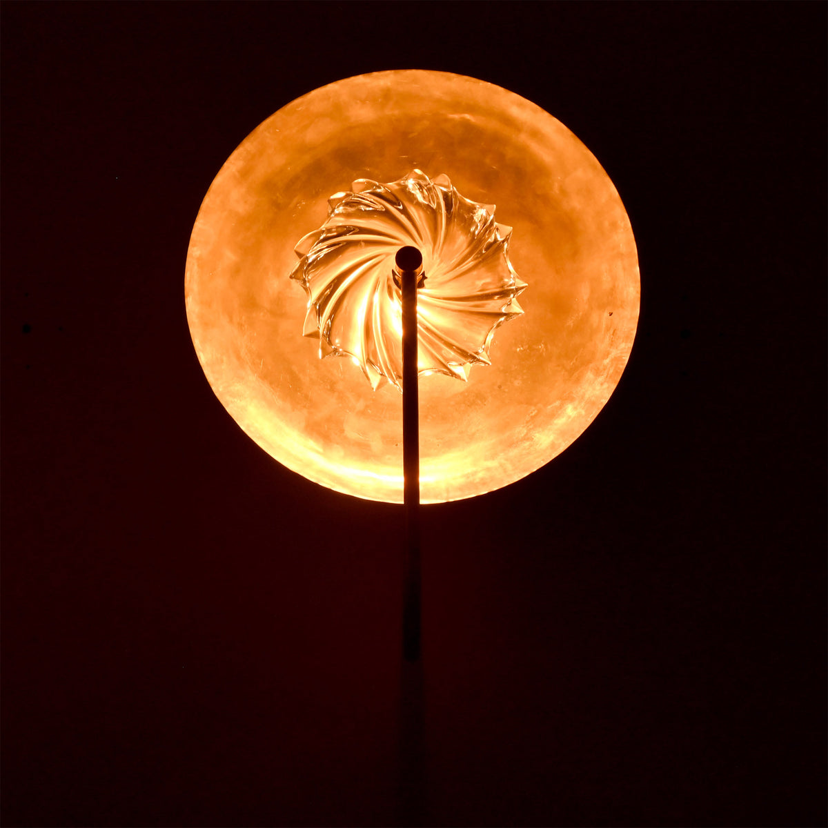 Close glow detail of Solara halo wall sconce showing textured glass center and warm circular backlight.