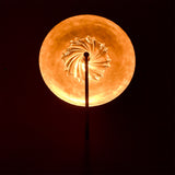 Close glow detail of Solara halo wall sconce showing textured glass center and warm circular backlight.