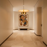 Sonoma 4 light sculptural chandelier shown from the front with a wide cream disc shade, brass-tone bowl lights, and slender downrod.